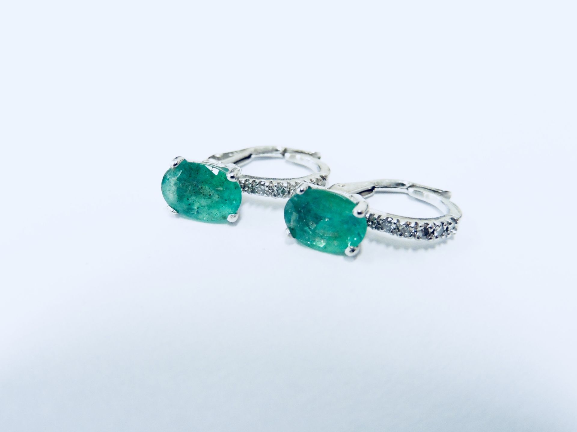 1.60ct emerald and diamond hoop style earrings. Each is set with a 7x 5mm oval cut emerald ( treated - Image 3 of 4