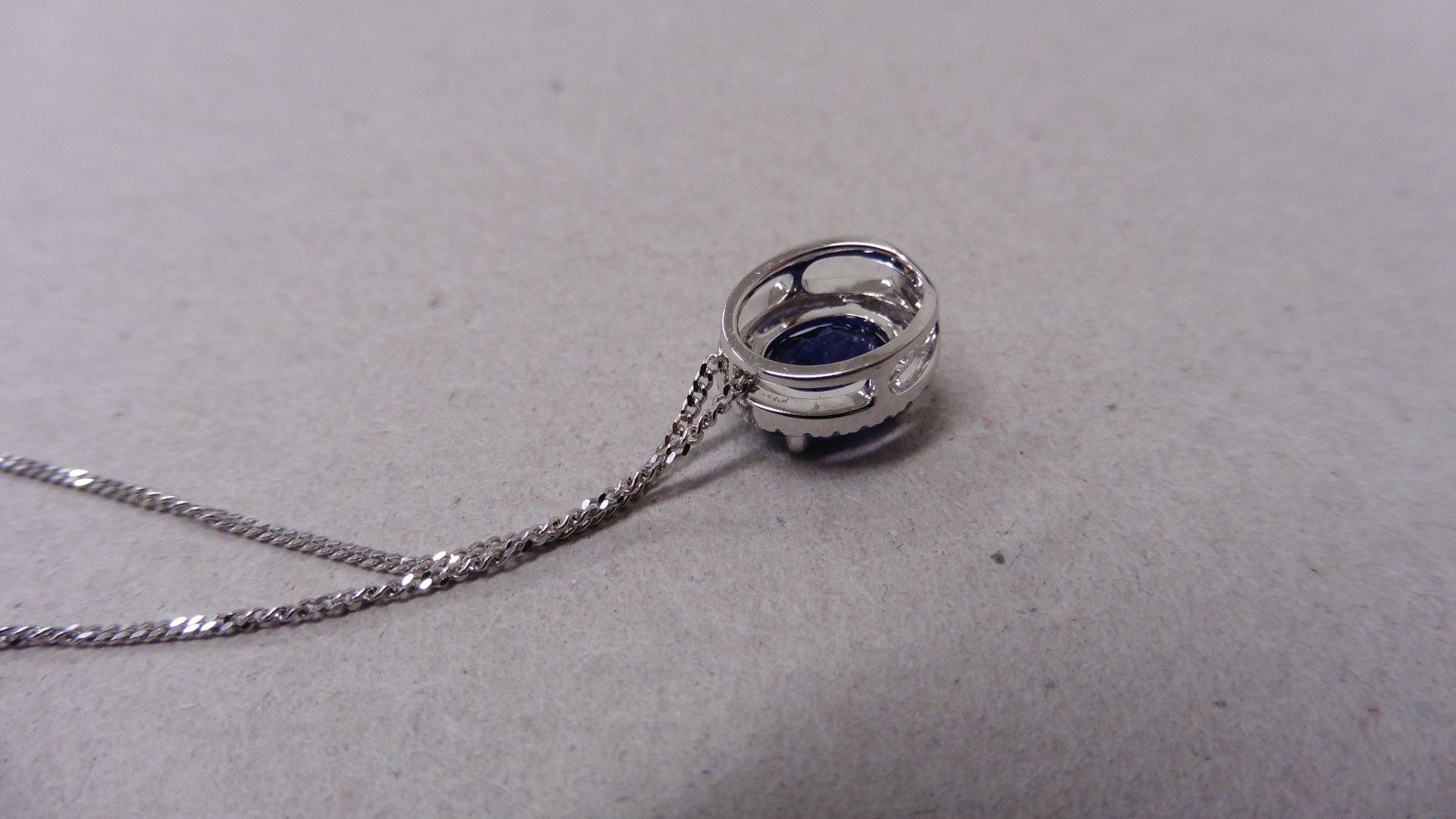 0.80ct halo set diamond pendant. Oval cut sapphire ( glass filled ) in the centre, 0.80ct, with a - Image 3 of 4