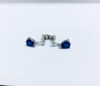 0.70ct drop style earrings. Each set with a pear-shaped Sapphire ( glass filled ) and a small