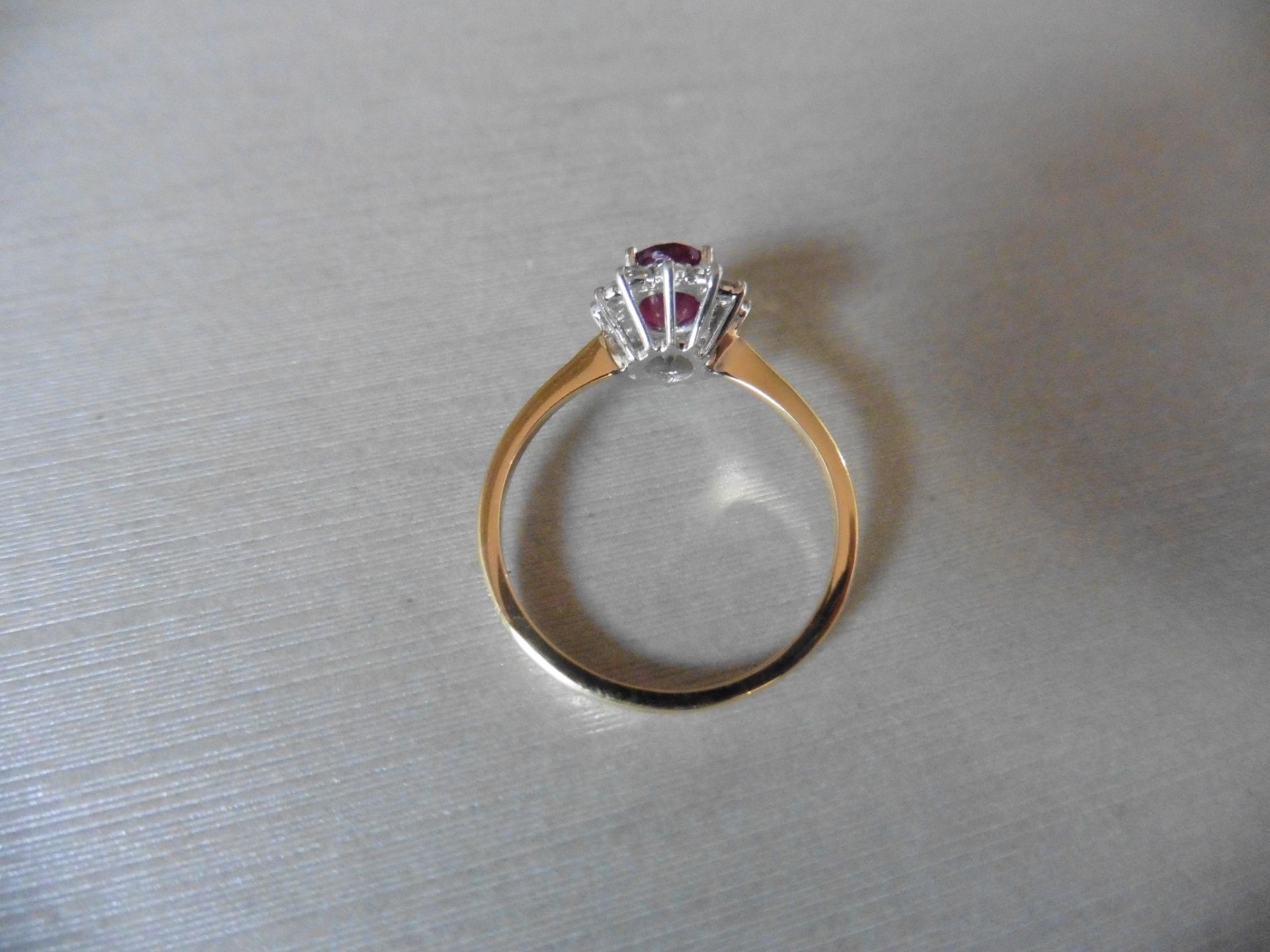 0.75ct / 0.30ct ruby and diamond cluster ring. Oval cut ( glass filled )ruby surrounded by small - Image 2 of 3