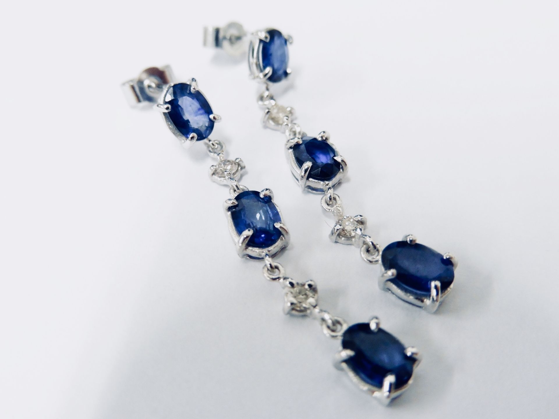 Sapphire and diamond drop style earrings set in 18ct gold. Each set with 3 oval cut ( treated)