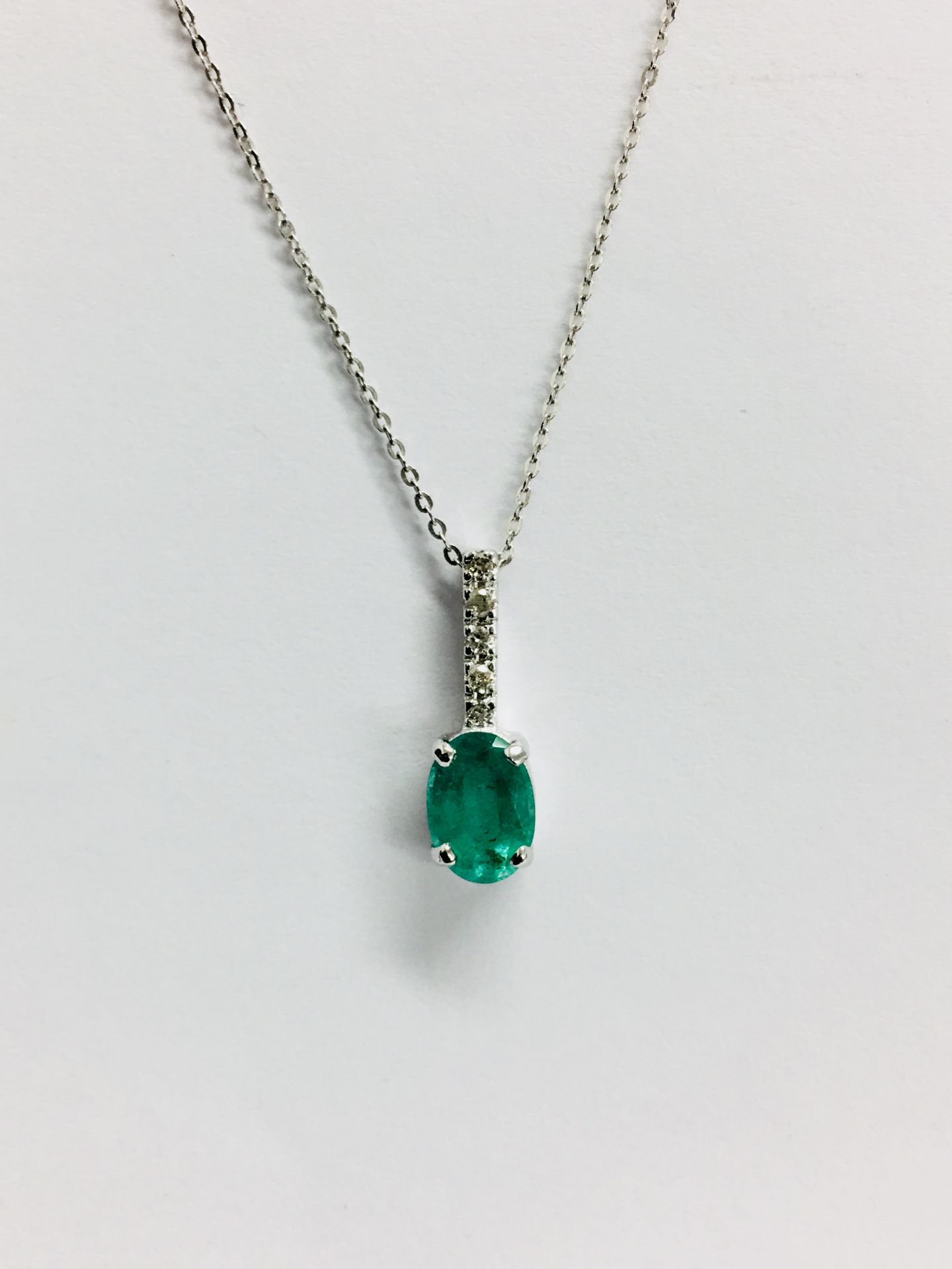 0.80ct emerald and diamond drop style pendant. 7X 5mm oval emerald set with 5 small brilliant cut