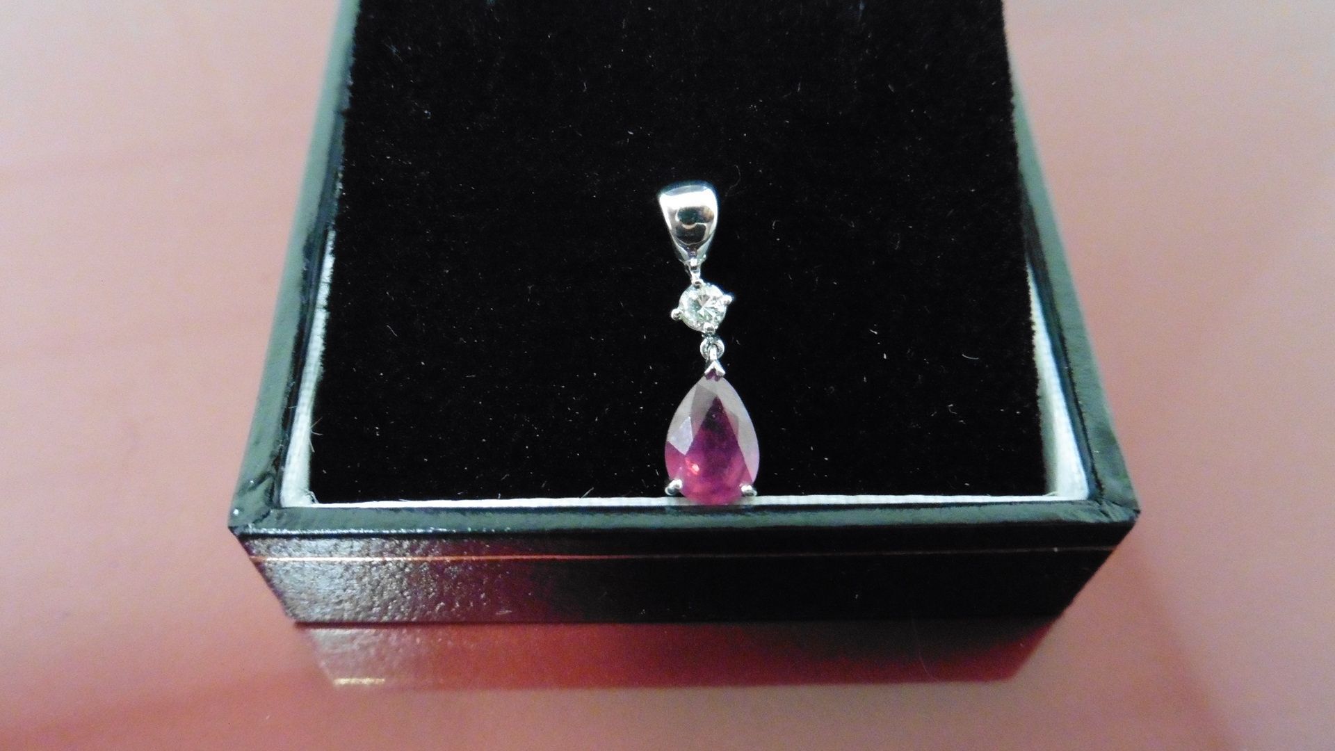 0.35ct ruby and diamond drop style pendant ( no chain ).Pear shaped ruby ( glass filled ) 0.35ct