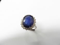 8.50ct sapphire and diamond cluster dress ring set in platinum. Oval cut sapphire ( fracture