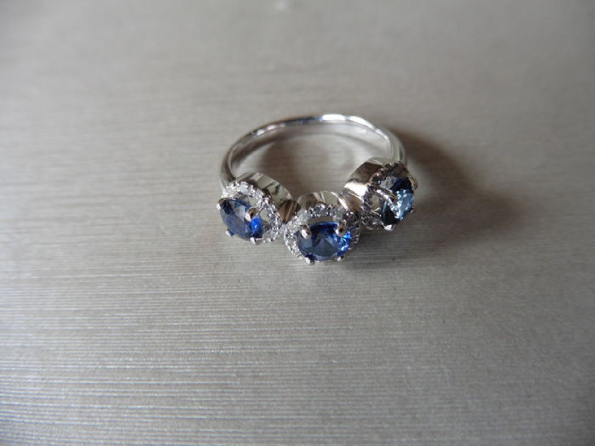 18ct white gold trilogy ring set with 3 round cut sapphires weighing 0.70ct. These are surrounded in - Bild 2 aus 3