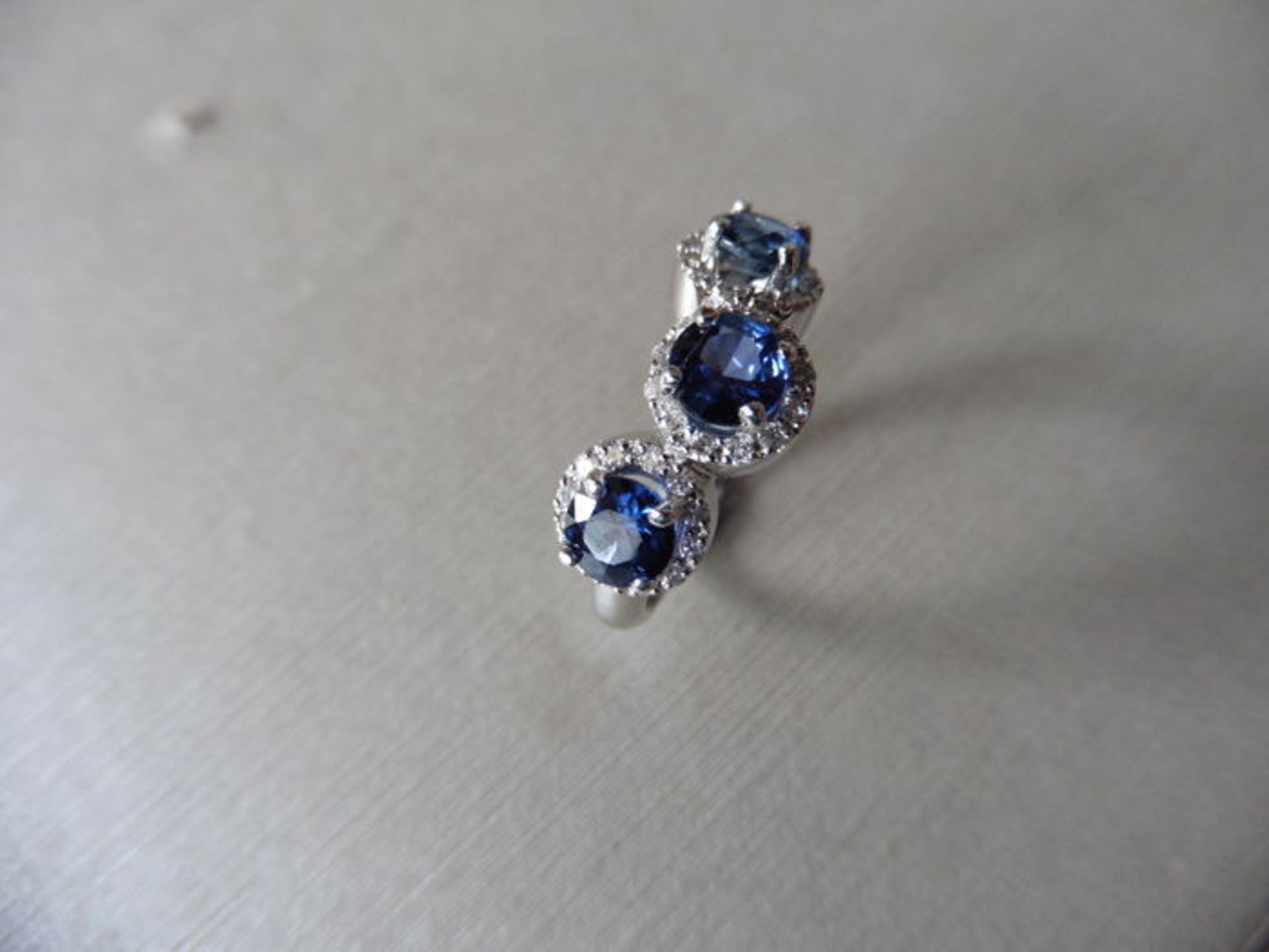 18ct white gold trilogy ring set with 3 round cut sapphires weighing 0.70ct. These are surrounded in - Image 3 of 3
