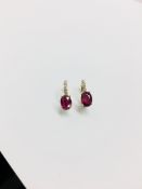 1.60ct Ruby and diamond hoop style earrings. Each is set with a 7x 5mm oval cut Ruby ( treated )