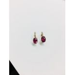 1.60ct Ruby and diamond hoop style earrings. Each is set with a 7x 5mm oval cut Ruby ( treated )