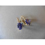 1.60ct Tanzanite and diamond hoop style earrings. Each is set with a 7x 5mm oval cut Tanzanite (