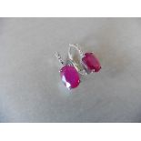 1.60ct Ruby and diamond hoop style earrings. Each is set with a 7x 5mm oval cut Ruby (treated)
