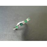 0.40ct emerald and diamond eternity style ring. Set with 4 round cut emeralds and 3 diamonds. Size