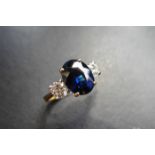 2.40ct sapphire and diamond trilogy ring. Oval cut ( glass filled ) sapphire in the centre with 2