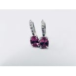 1.60ct Pink Tourmaline and diamond hoop style earrings. Each is set with a 7x 5mm oval cut
