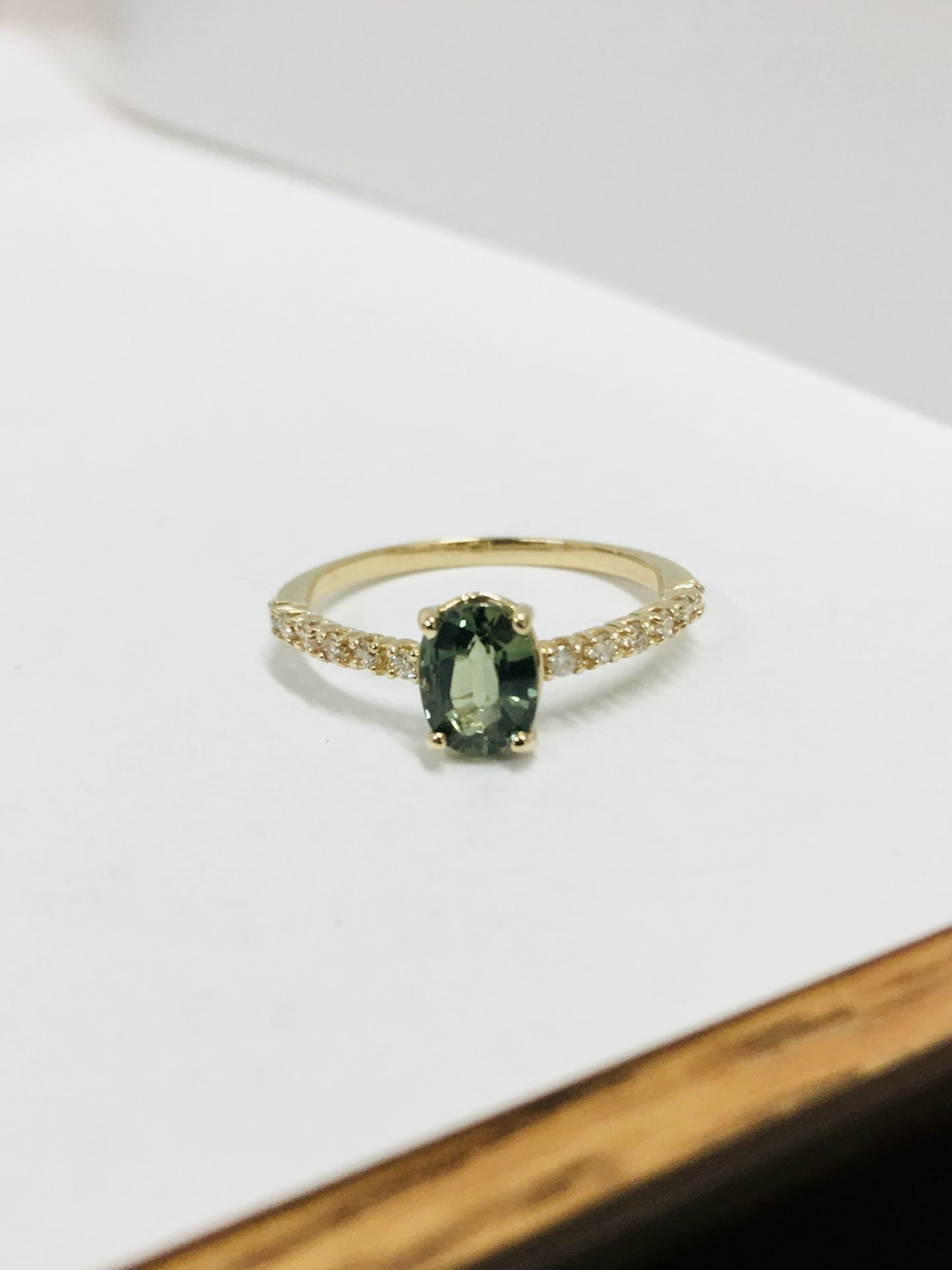 0.80ct / 0.12ct green sapphire and diamond dress ring. Oval cut ( treated ) sapphire with small