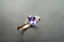 0.80t tanzanite and diamond dress ring. Oval cut ( treated ) tanzanite with 3 small brilliant cut