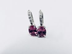 1.60ct Pink Tourmaline and diamond hoop style earrings. Each is set with a 7x 5mm oval cut