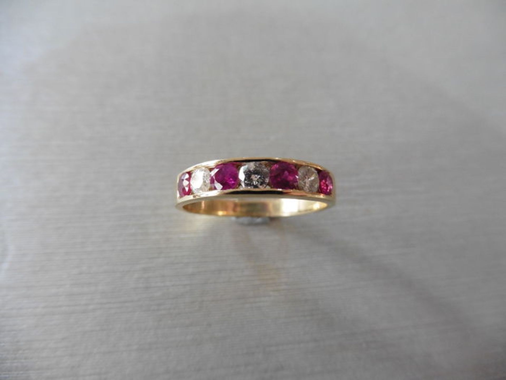 Ruby and diamond eternity band ring set in 9ct yellow gold. 4 small round cut rubies ( treated ) 0. - Image 2 of 3