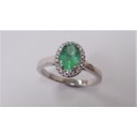 Emerald and Diamond cluster ring set in platinum. Oval cut emerald ( treated ) 1ct, surrounded by