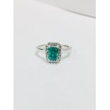 Emerald and diamond ring. Rectangular cut emerald ( treated ) 0.70ct with a halo setting of small