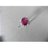 Ruby and diamond cluster style ring set in platinum. Oval cut ( fracture filled ) ruby 2.50ct with