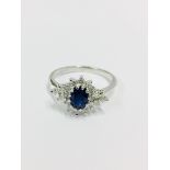 Sapphire and diamond cluster style ring set in platinum. Oval cut ( treated ) sapphire 1ct with 0.