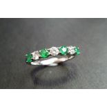 emerald and diamond seven stone band ring. 4 round cut emeralds and 3 brilliant cut diamonds. 1ct