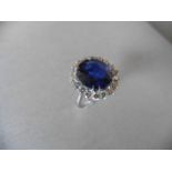 Sapphire and diamond cluster ring set in platinum. Oval cut sapphire ( fracture filled ) 6.50ct