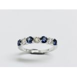 Sapphire and diamond eternity style ring. 4 round cut sapphires ( treated) 3 brilliant cut diamonds.