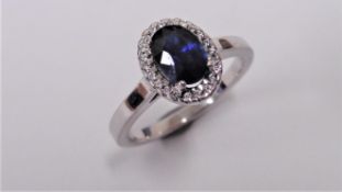 Sapphire and Diamond cluster ring set in platinum. Oval cut sapphire ( fracture filled ) 1ct,