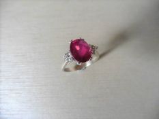 Ruby and diamond dress ring set in platinum. Oval cut ruby ( fracture filled ) 2.40ct approx with