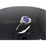 Sapphire and diamond cluster style ring set in platinum. Oval cut ( treated ) sapphire 1ct with 0.