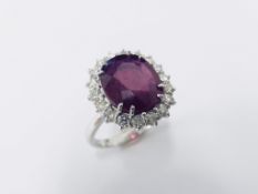 6ct ruby and diamond cluster ring set in platinum. Oval cut colour treated ( fracture filled )