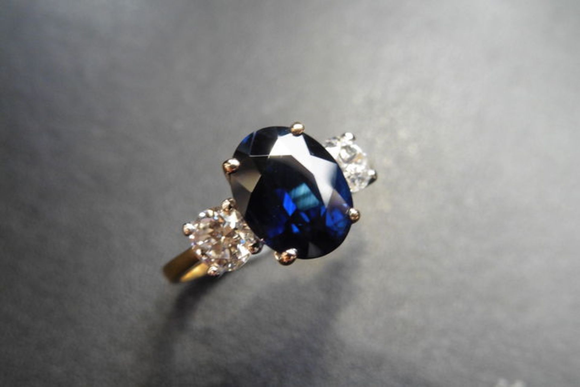 2.40ct sapphire and diamond trilogy ring. Oval cut ( glass filled ) sapphire in the centre with 2