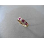 Ruby and diamond eternity band ring set in 9ct yellow gold. 4 small round cut rubies ( treated ) 0.