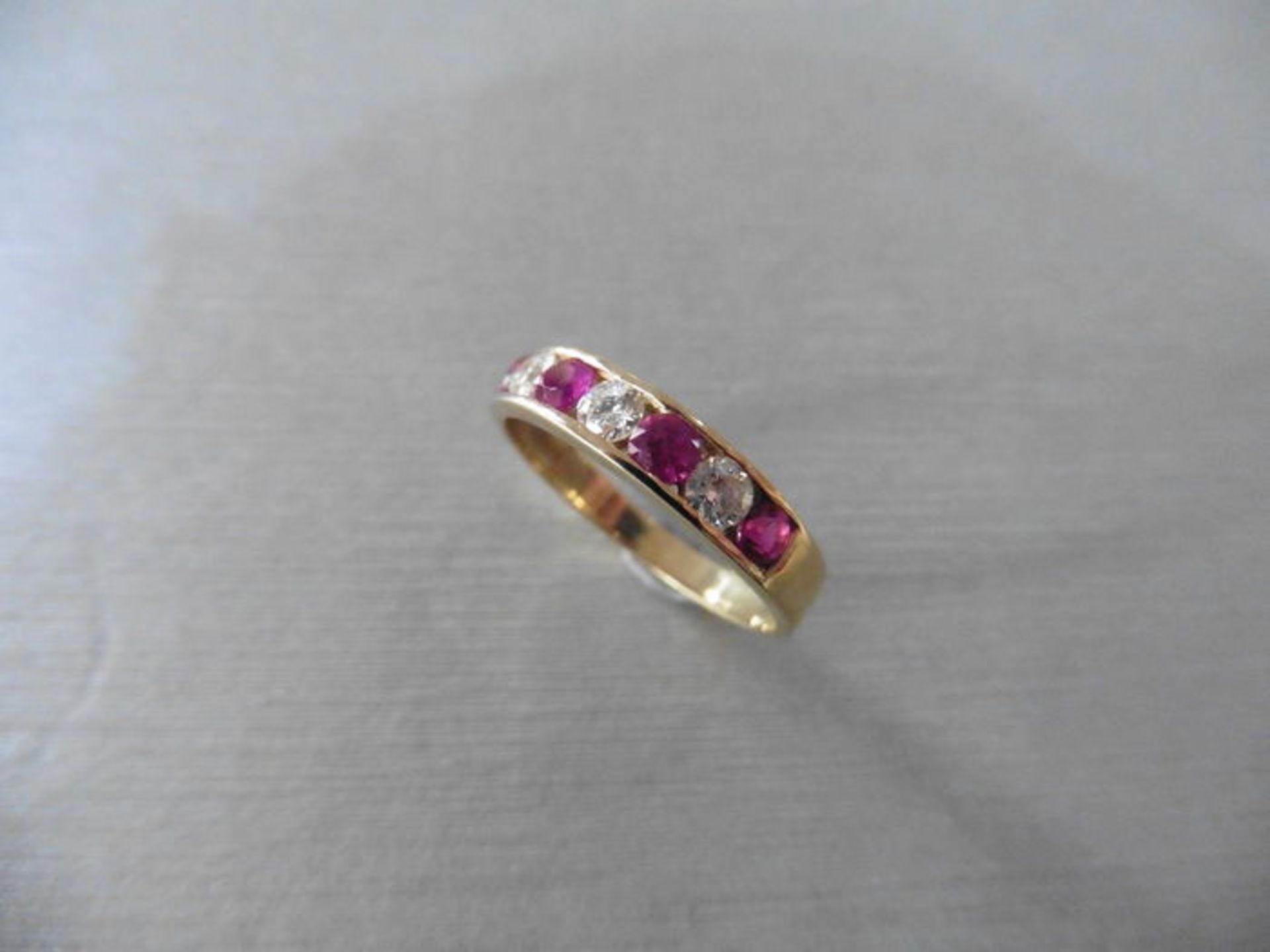Ruby and diamond eternity band ring set in 9ct yellow gold. 4 small round cut rubies ( treated ) 0.