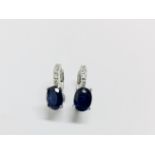 1.60ct sapphire and diamond hoop style earrings. Each is set with a 7x 5mm oval cut sapphire (