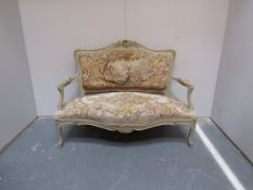 Ornate cream settee covered in a tapestry of courting couples