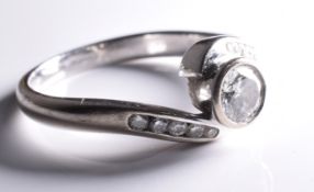 A diamond engagement ring with diamonds set down each shoulder