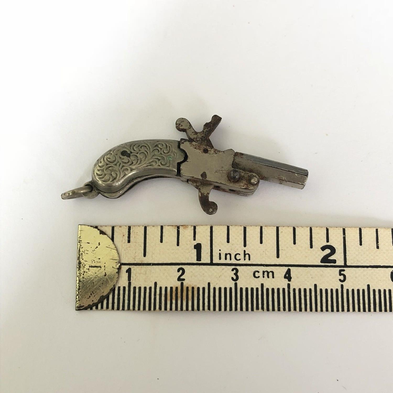 A Miniature Antique Tiny Spy Pistol - Berloque 2mm Pin Fire Gun with Scroll Grip