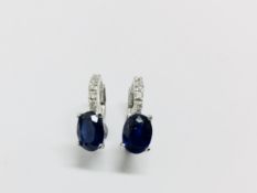 1.60ct sapphire and diamond hoop style earrings. Each is set with a 7x 5mm oval cut sapphire (