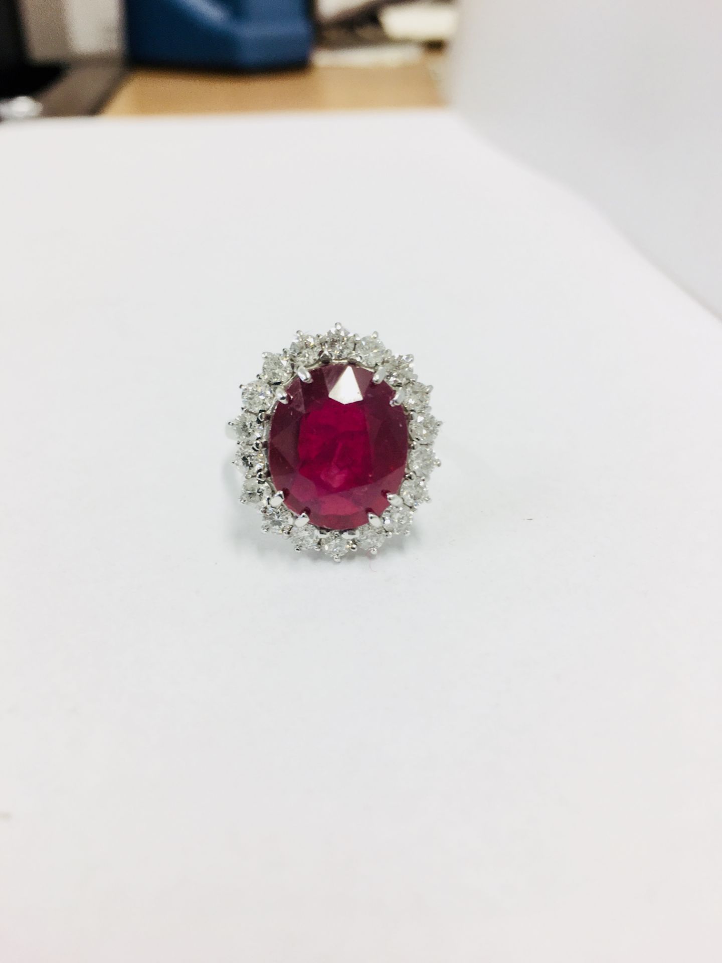 6ct ruby and diamond cluster ring set in platinum. Oval cut colour treated ( fracture filled )