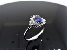 Sapphire and diamond cluster style ring set in platinum. Oval cut ( treated ) sapphire 1ct with 0.