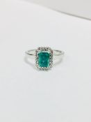 Emerald and diamond ring. Rectangular cut emerald ( treated ) 0.70ct with a halo setting of small
