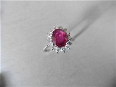 Ruby and diamond cluster style ring set in platinum. Oval cut ( fracture filled ) ruby 2.50ct with