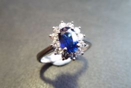 1ct sapphire and diamond cluster ring in platinum. Oval cut sapphire ( fracture filled )