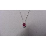 0.80ct ruby and diamond pendant. 7 x5mmoval cut ( glass filled ) ruby with a halo setting of small