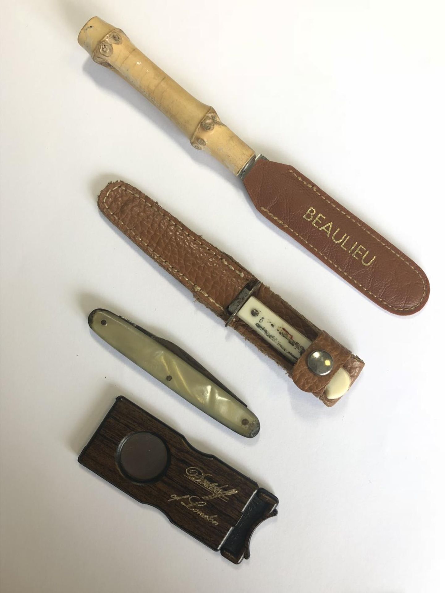 A Davidoff of London cigar cutter together with a group of vintage pocket knives or fruit knives