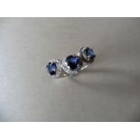 18ct white gold trilogy ring set with 3 round cut sapphires weighing 0.70ct. These are surrounded in