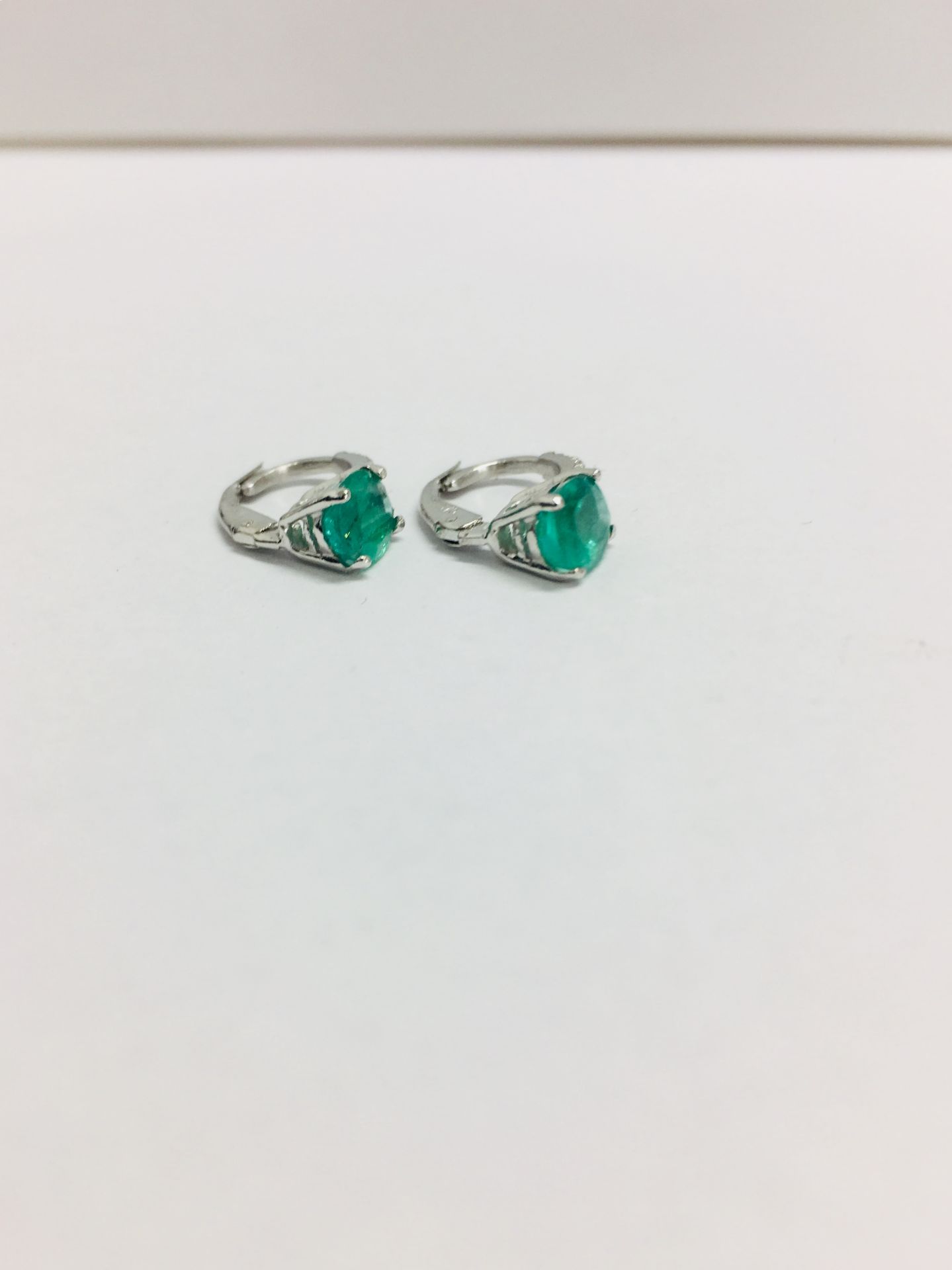 1.60ct emerald and diamond hoop style earrings. Each is set with a 7x 5mm oval cut emerald ( treated - Image 2 of 3