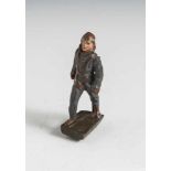 Figur Flieger, polychrom bemalte Masse, im Marsch auf rechteckiger flacher Plinthe. H. ca. 7 cm,